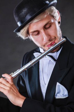 Zarif giyimli erkek müzisyen flüt çalmaya