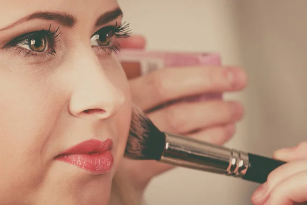 Mujer haciendo su maquillaje con cepillo profesional —  Fotos de Stock