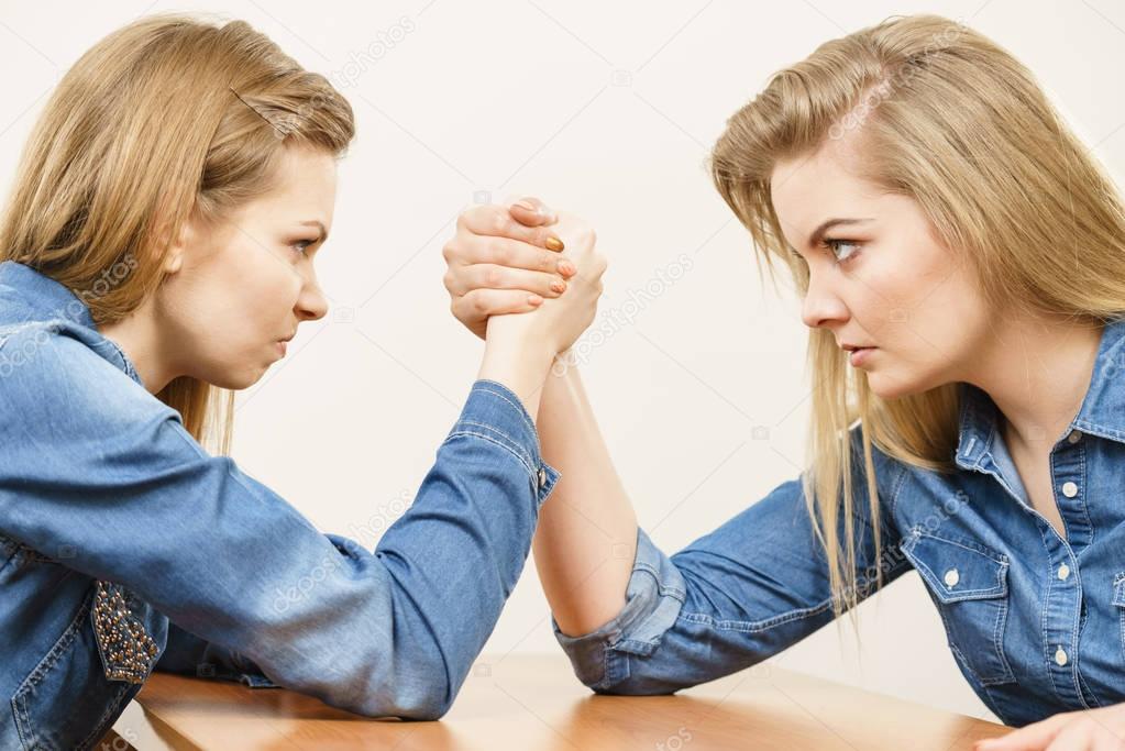 Two women having arm wrestling fight