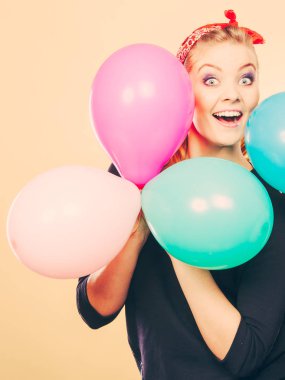 Balonlarla eğleniyor gülümseyen çılgın kız.