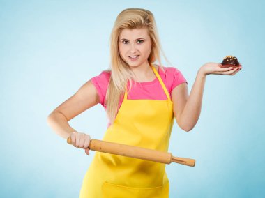 Cupcake ve oklava önlük giyen tutan kadın