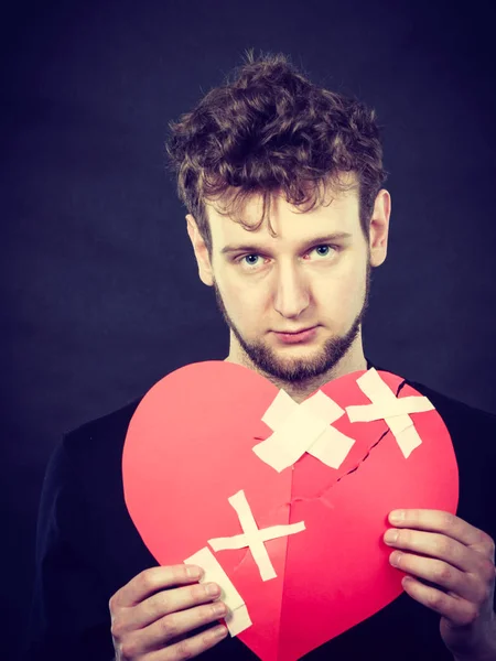 Triste hombre con el corazón pegado por yeso . — Foto de Stock