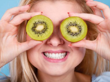 Gözlük gibi yeşil kivi tutan kadın