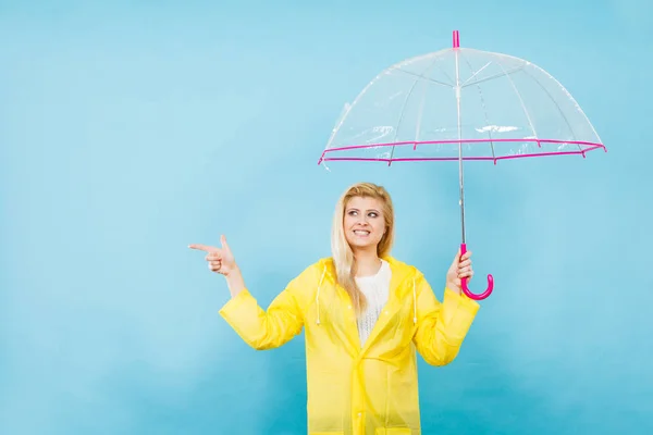 Kobieta nosi płaszcz gospodarstwo wskazujący parasol — Zdjęcie stockowe