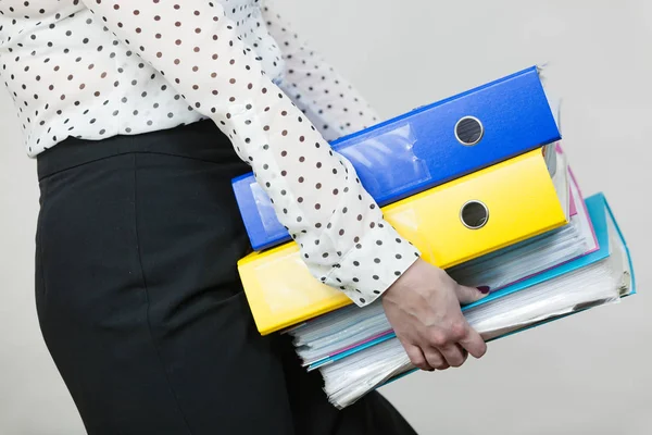 Donna che tiene pesanti raccoglitori colorati con documenti — Foto Stock