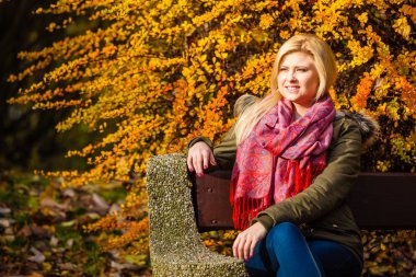 Sonbahar parkta bankta oturmuş rahatlatıcı kadın