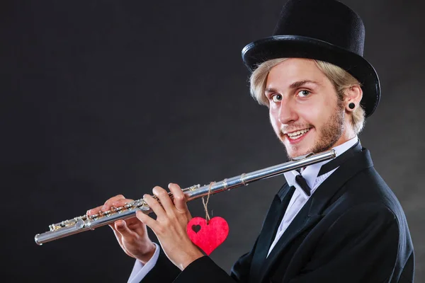 Мужчина флейтист с флейтой и сердцем. Любовная мелодия — стоковое фото