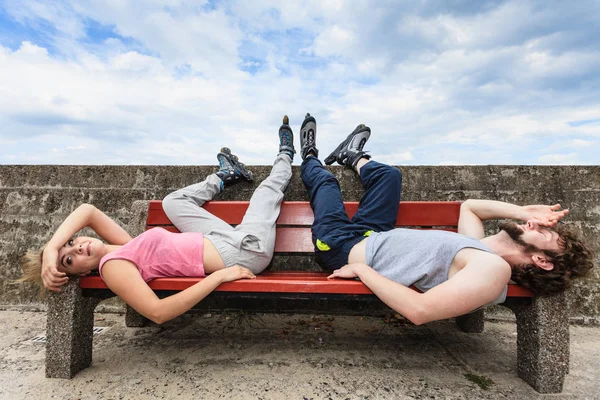 Unga trötta människor vänner avkopplande på bänk. — Stockfoto