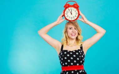 Mavi çalar saat ile gülümseyen kız.