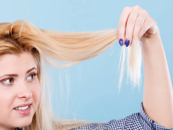 Mujer rubia sosteniendo sus puntas de pelo —  Fotos de Stock