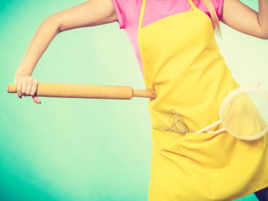 Holding kevgir ve oklava önlük giyen kadın