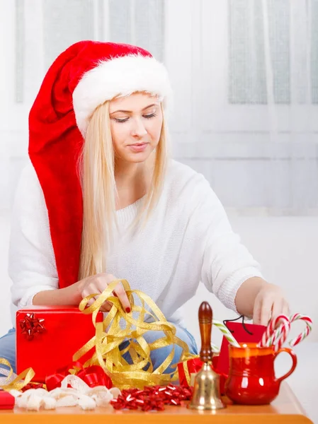 Young woman preparing gifts for Christmas