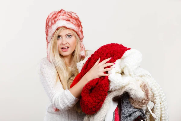 Γυναίκα με καπέλο χειμώνα κρατά το σωρό ρούχα — Φωτογραφία Αρχείου