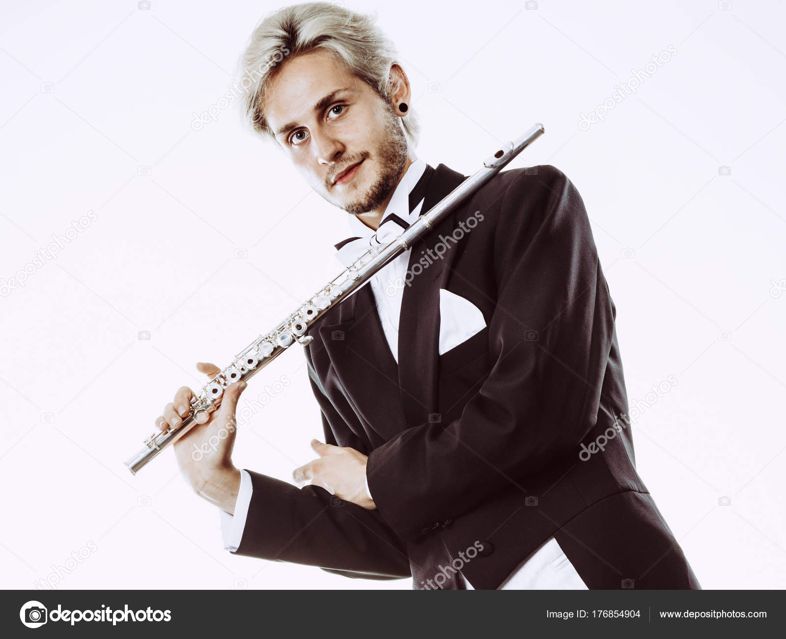 Male flutist wearing tailcoat holds flute Stock Photo by