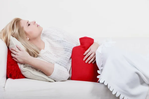 Cofa üzerinde yatan kadın duygu mide krampları — Stok fotoğraf