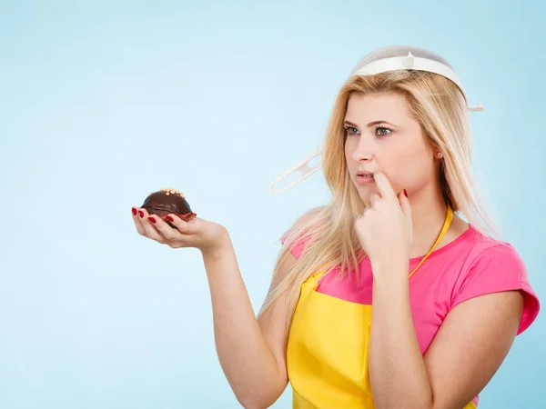 Woman holding cupcake wearing colander on head — Stock Photo, Image