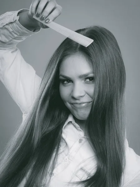 Mujer de pelo largo peinándose el pelo . — Foto de Stock