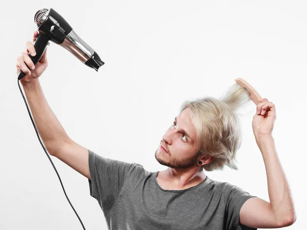 Joven hombre secando el cabello con secador de pelo — Foto de Stock