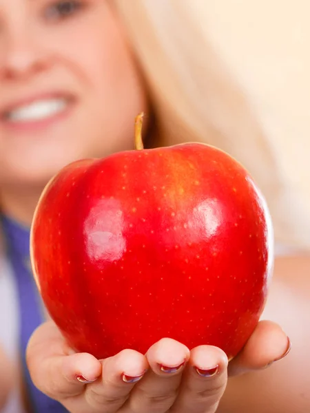 Mujer con cinta métrica alrededor del cuello sosteniendo manzana — Foto de Stock