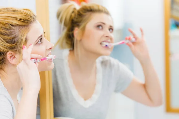 Woman brushing cleaning teeth in bathroom — Stock Photo, Image