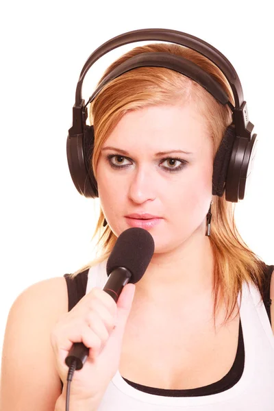 Mulher cantando ao microfone usando fones de ouvido — Fotografia de Stock