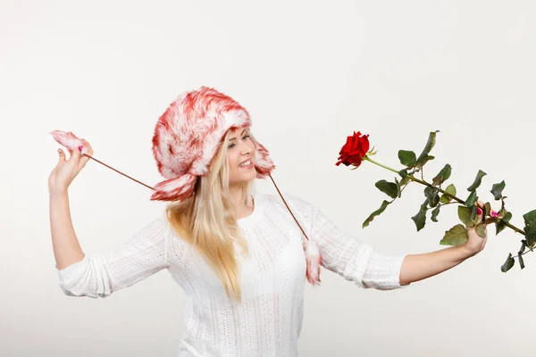 Женщина в зимней пушистой шляпе с красной розой — стоковое фото