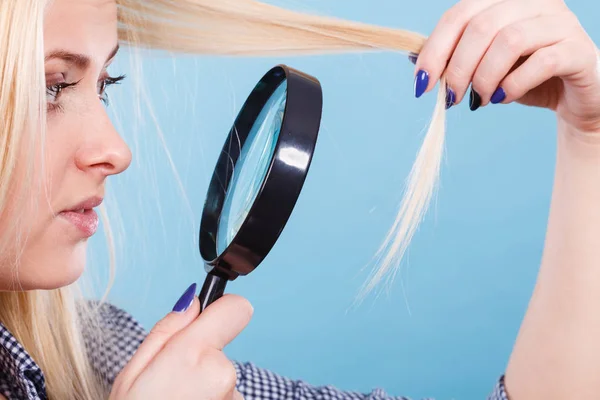 Frau betrachtet Haare durch Lupe — Stockfoto