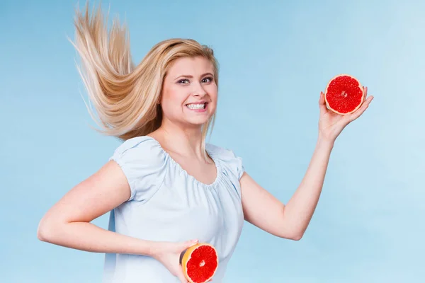 Mulher segurando fruta toranja vermelha metade — Fotografia de Stock