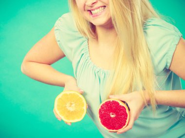 Kırmızı ve yeşil greyfurt tutan kadın