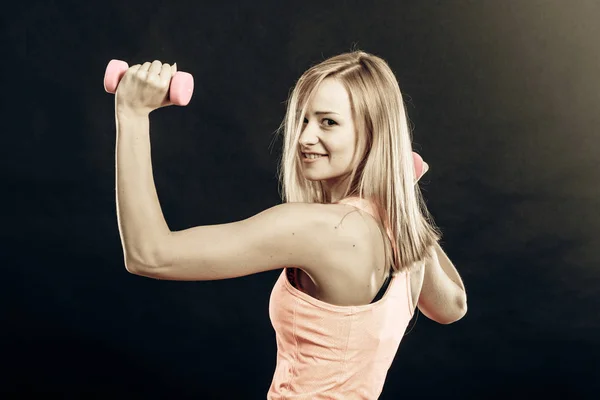 Fitness-Mädchen mit Kurzhanteln lässt Muskeln im Fitnessstudio spielen — Stockfoto