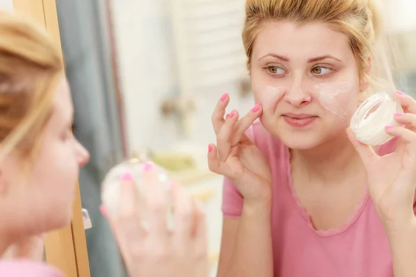 Kvinna tillämpning ansiktskräm med hennes finger — Stockfoto