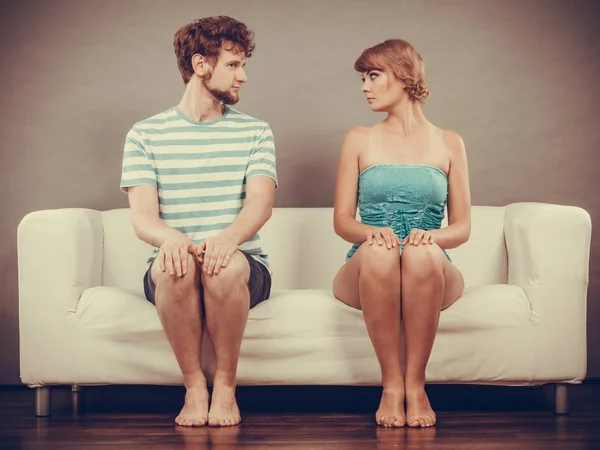 Wanita dan pria duduk di sofa melihat satu sama lain . — Stok Foto