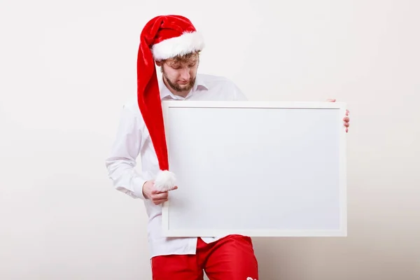 Man in santa hat with blank banner. Copy space.