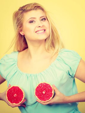Kırmızı greyfurt meme üzerinde tutan kadın