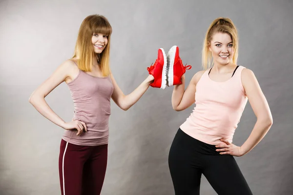 Due donne che presentano scarpe da ginnastica sportive — Foto Stock