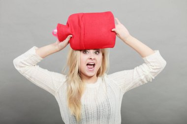 Kırmızı sıcak su şişesi üzerinde kafa tutan kadın