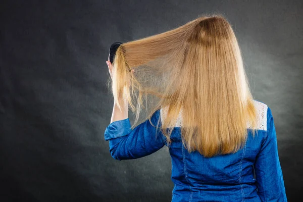 Mujer rubia peinándose el pelo . — Foto de Stock