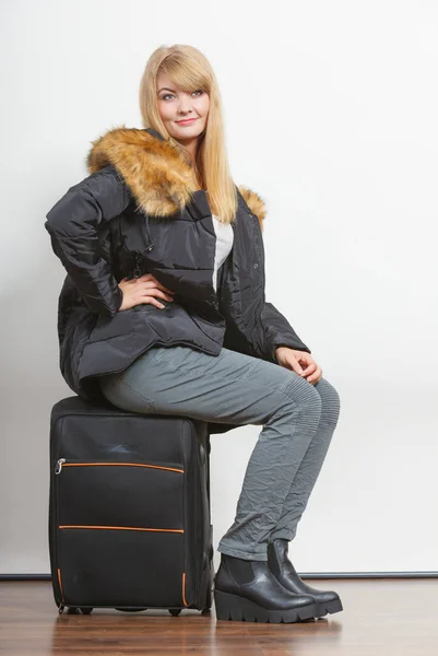 Junge Frau in warmer Jacke mit Koffer. — Stockfoto