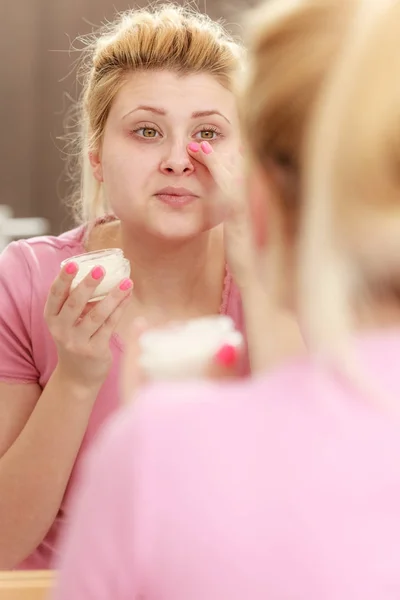 Mujer aplicando crema facial con el dedo — Foto de Stock