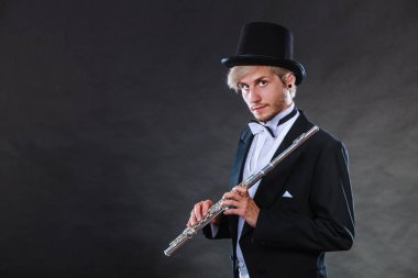 Zarif giyimli müzisyen flüt tutan