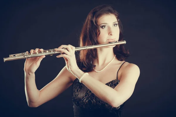 Mulher tocando flauta transversal no preto . — Fotografia de Stock