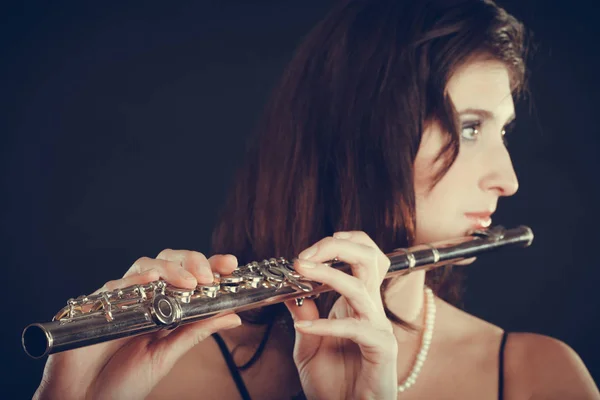 Donna che suona il flauto trasversale sul nero . Foto Stock Royalty Free