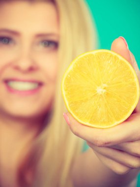 Meyve limon ya da portakal tutan kadın