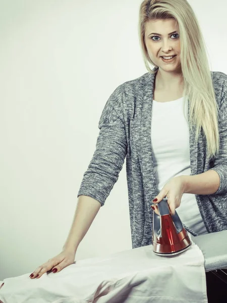 Woman holding iron about to do ironing — Stock Photo, Image