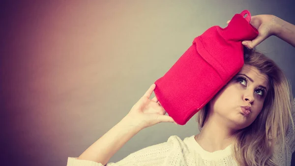 Kvinna med röd varmvattenflaska på huvud — Stockfoto