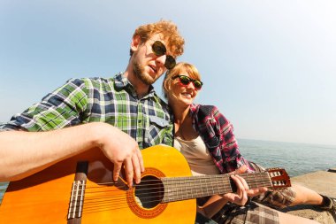 Genç kadın için gitar çalmak hipster adam.