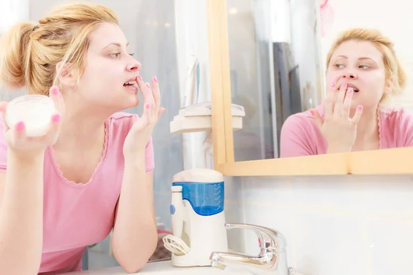 Mujer aplicando crema facial con el dedo — Foto de Stock