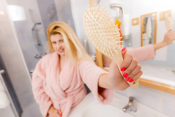 Mulher feliz segurando mostrando sua escova de cabelo — Fotografia de Stock