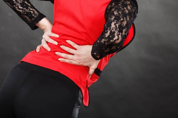 Женщина в элегантной одежде с болью в спине — стоковое фото