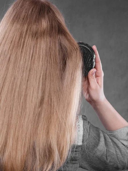 Blond kvinna kammar sitt hår. — Stockfoto